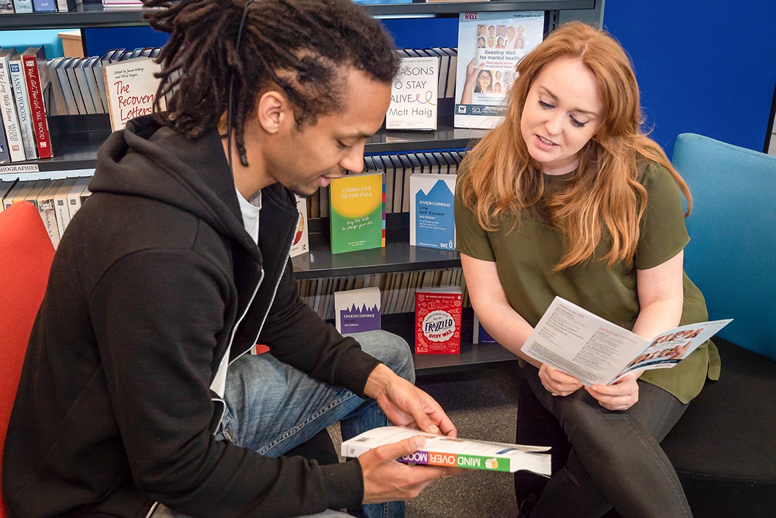 Library User being shown Reading Well books